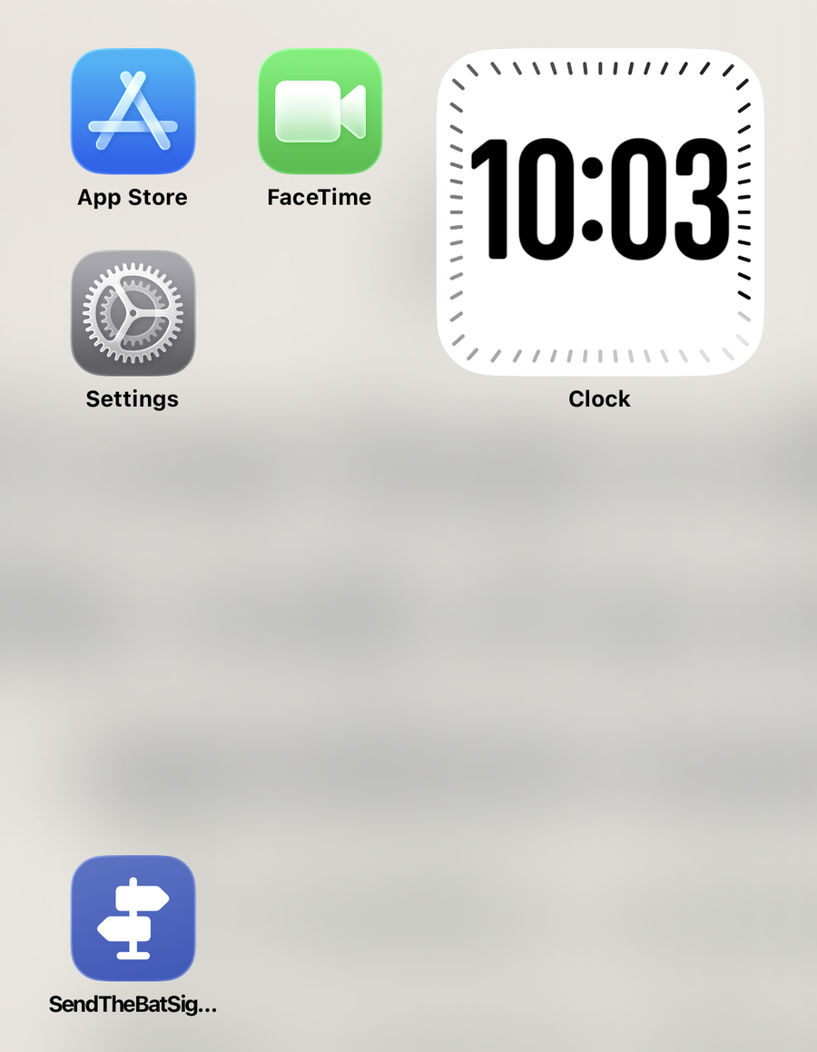 An iPhone home screen with the Bat Signal shortcut sitting in the bottom row like any other app
