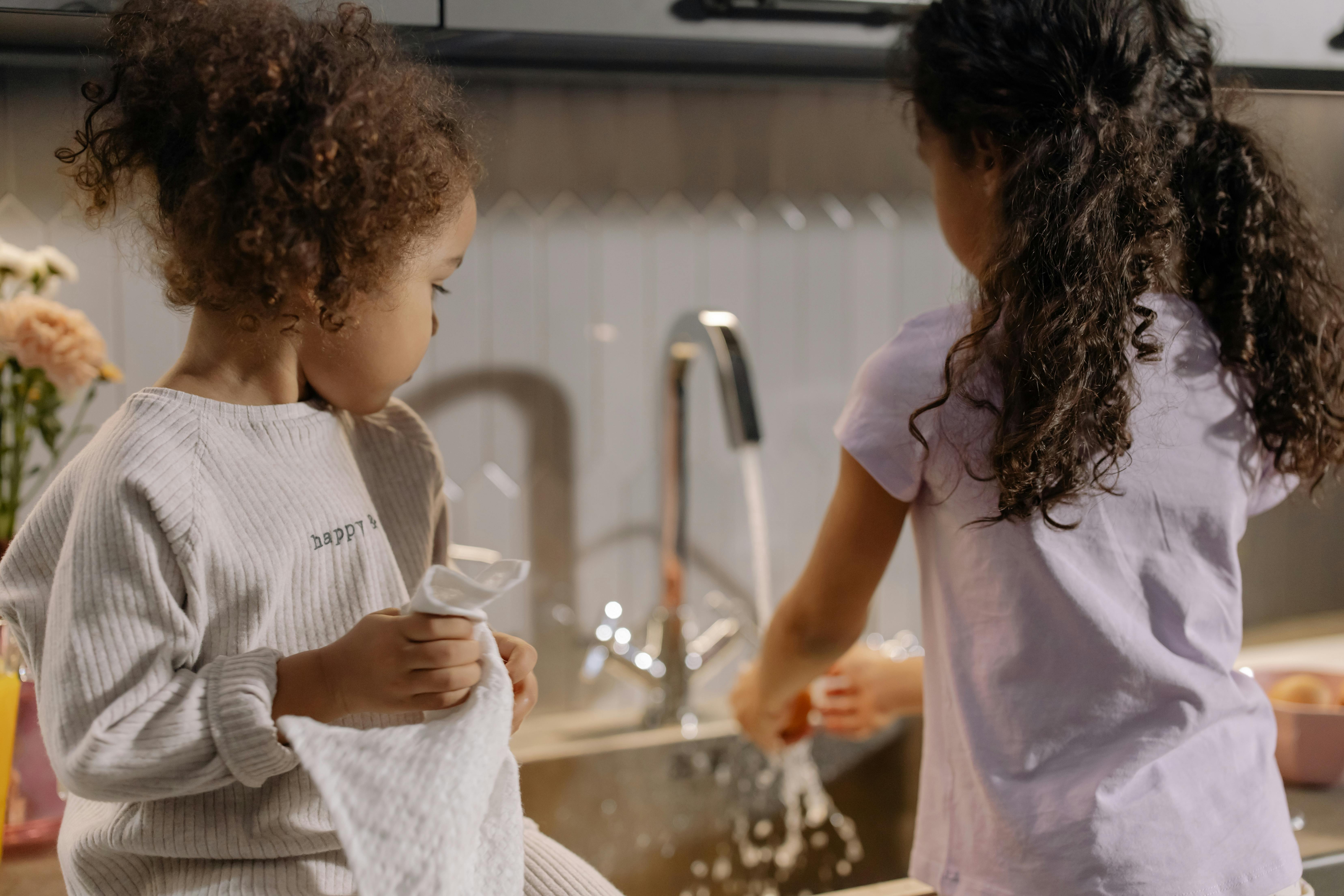 Kids actively doing chores in the kitchen, natural and cooperative